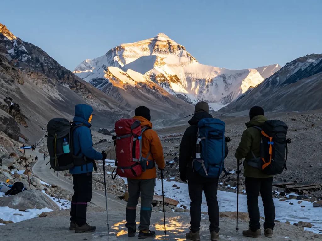 Group on Everest Base Camp Trek standing at Kalapatthar with breathtaking mountain views and sunrise lighting.